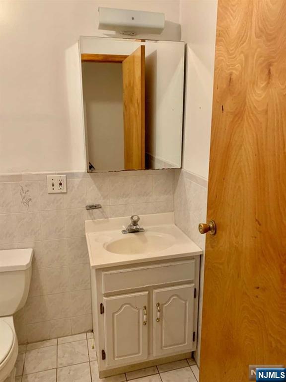 422 A Warren Street, Unit 1F Harrison, NJ 07029 - Photo 10 of 11 a bathroom with a sink a toilet and mirror