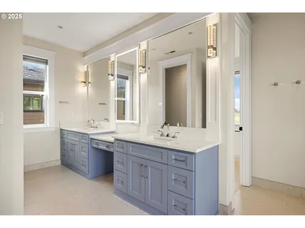 a bathroom with a granite countertop double vanity sink a mirror and a bathtub