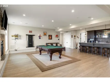 a living room with furniture a flat screen tv and a refrigerator