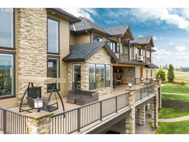 a view of a house with a wooden deck and furniture
