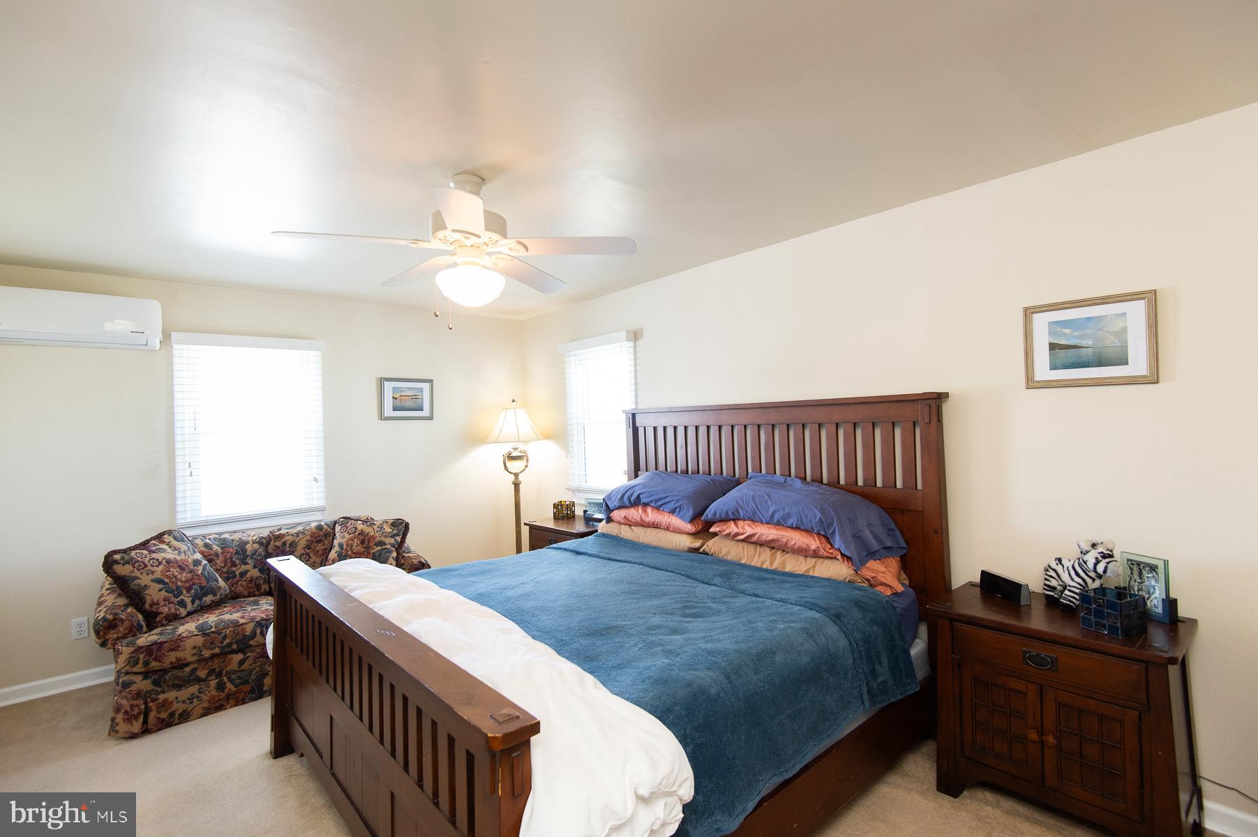 5558 Bowen Road Cambridge, MD 21613 - Photo 13 of 33 a bedroom with a bed and a chandelier