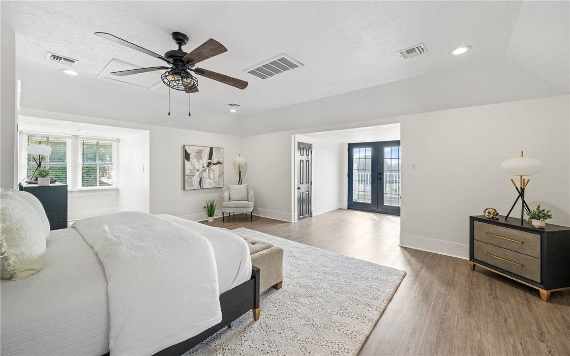 514 West 4th Street Sinton, TX 78387 - Photo 19 of 32 a spacious bedroom with a large bed and a chandelier