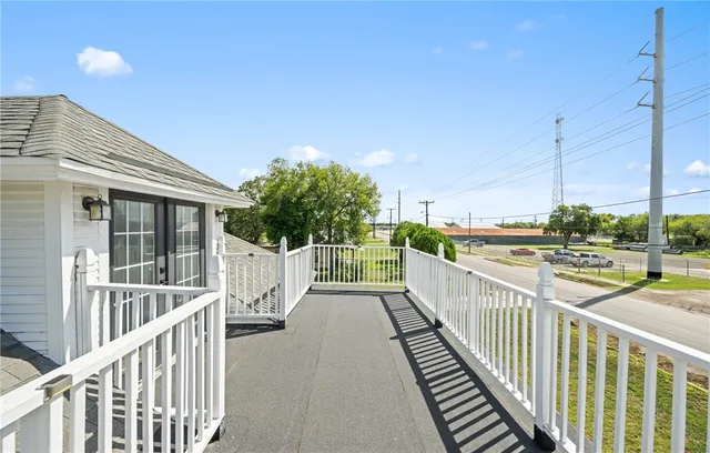 a view of a balcony with floor to ceiling window and wooden fence