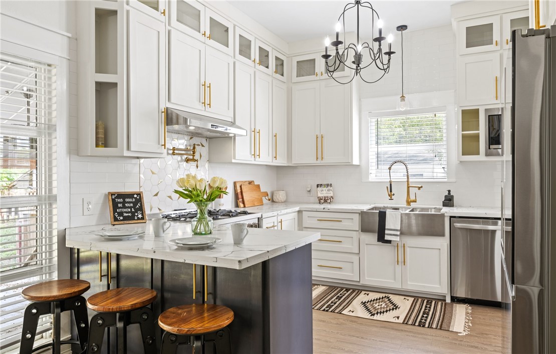 514 West 4th Street Sinton, TX 78387 - Photo 7 of 32 a kitchen with stainless steel appliances granite countertop a white refrigerator a sink dishwasher a dining table and chairs with wooden floor
