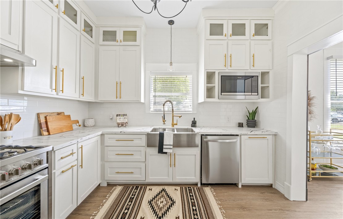 514 West 4th Street Sinton, TX 78387 - Photo 8 of 32 a kitchen with stainless steel appliances granite countertop a stove and cabinets