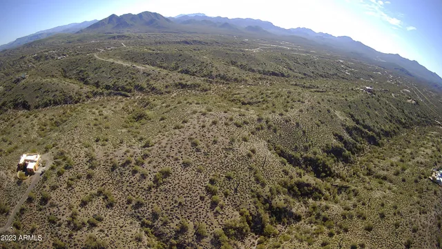 a view of a big yard with mountains in the background