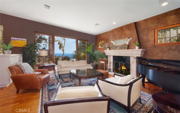 a living room with fireplace furniture and a large window