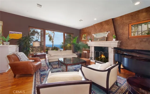 a living room with fireplace furniture and a large window