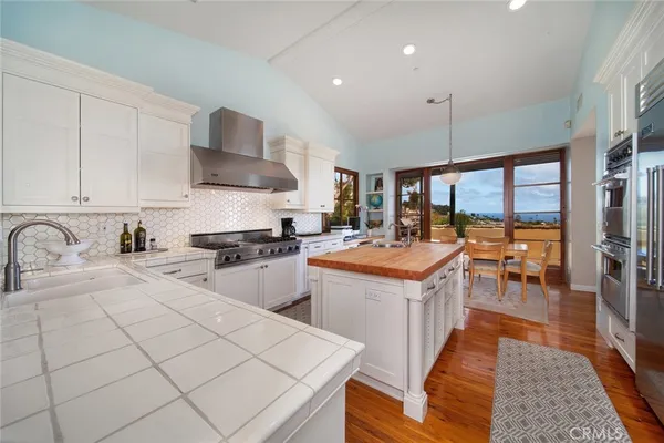 a kitchen with stainless steel appliances granite countertop a sink a stove and a refrigerator