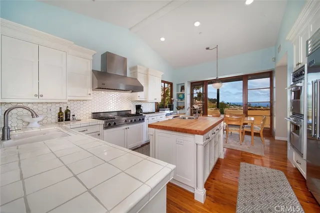 a kitchen with stainless steel appliances granite countertop a sink a stove and a refrigerator