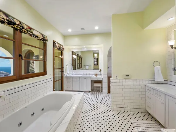 a bathroom with a tub a sink and a large mirror