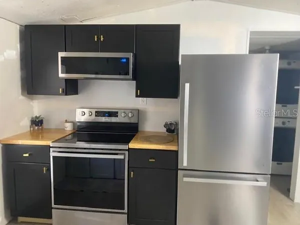 a kitchen with stainless steel appliances wooden cabinets and a refrigerator