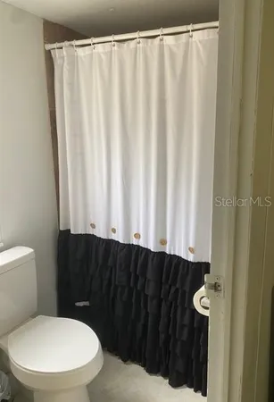 a bathroom with a toilet and a shower curtain