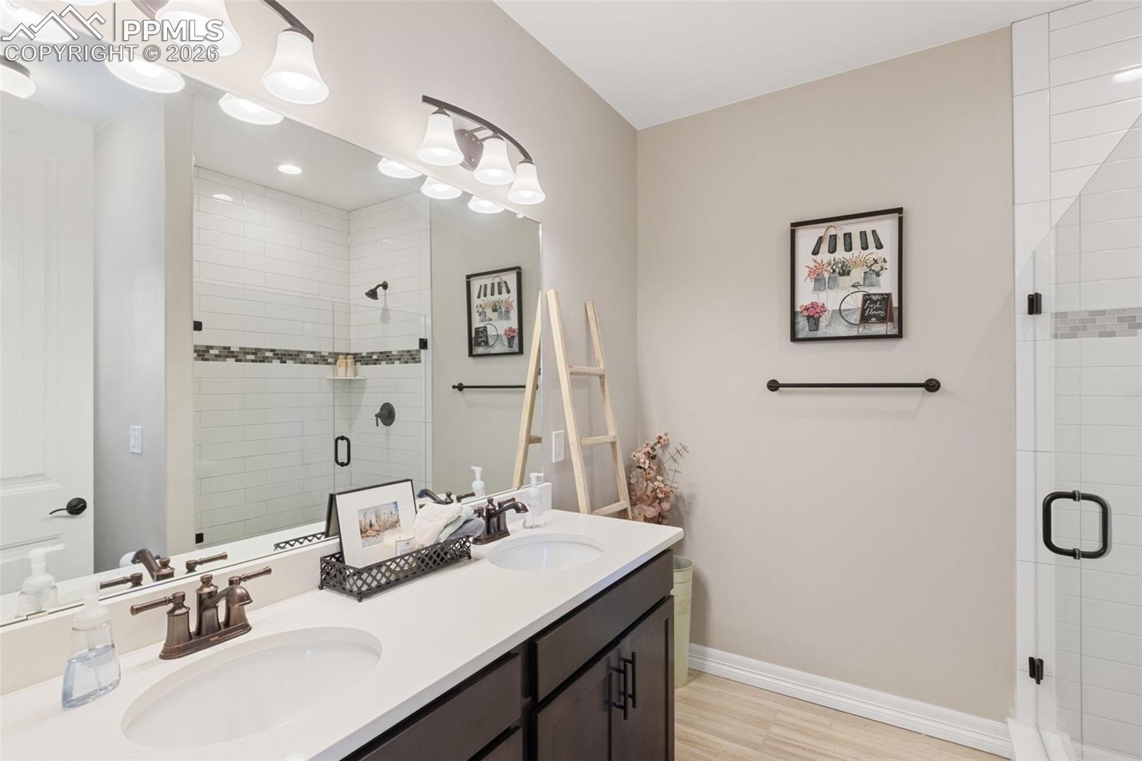 5318 Rocking Tree Grove Colorado Springs, CO 80906 - Photo 24 of 49 The bathroom offers a dual vanity and a walk-in glass shower that rivals most primary suites in scale and finish