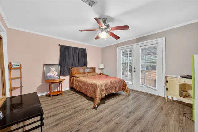 a spacious bedroom with a bed and wooden floor