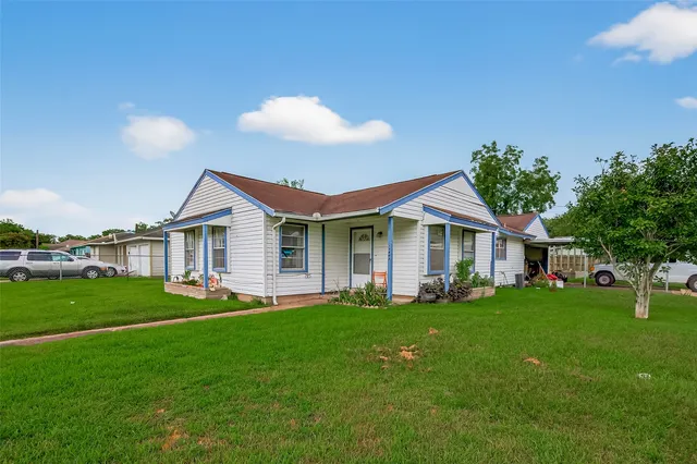 a front view of a house with a yard and trees