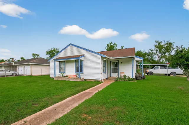 a view of a house with a yard and sitting area