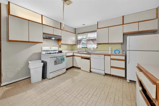 a kitchen with a sink cabinets stainless steel appliances and view living room