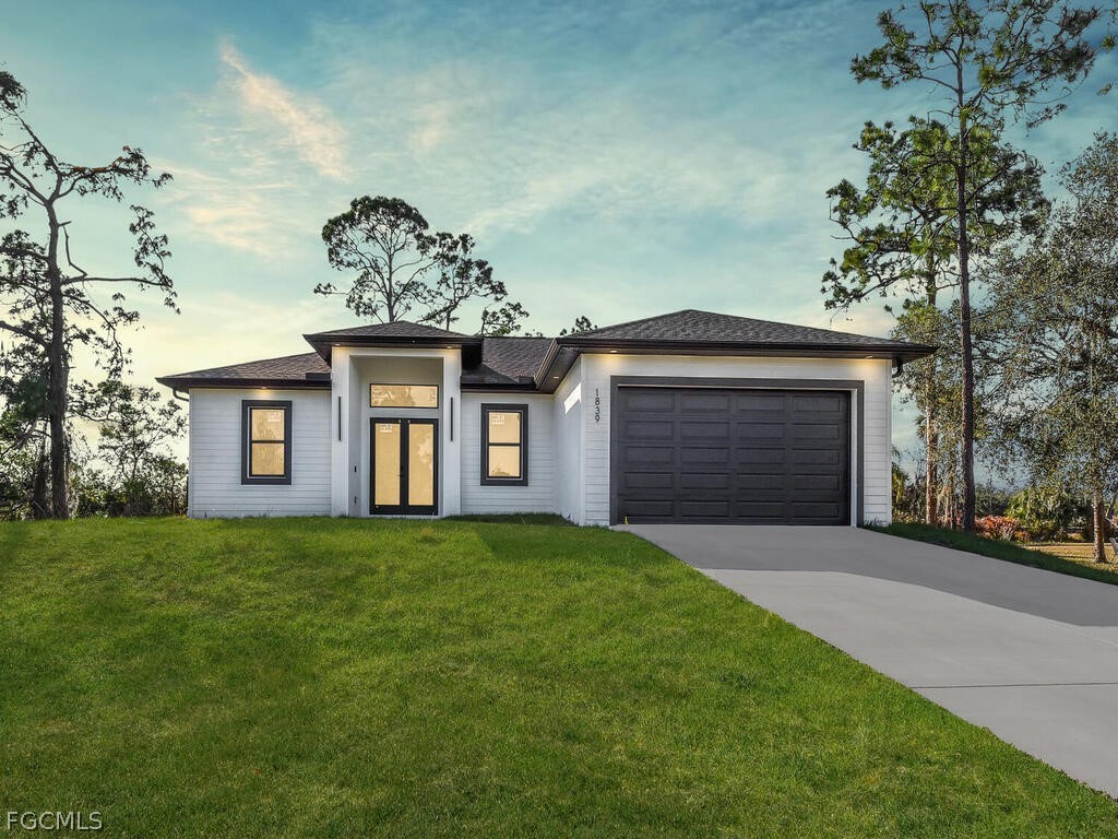 a front view of a house with a garden and yard
