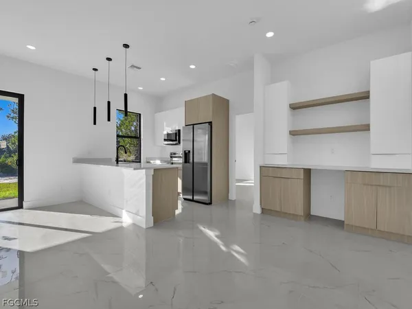 a kitchen with stainless steel appliances kitchen island sink refrigerator and microwave