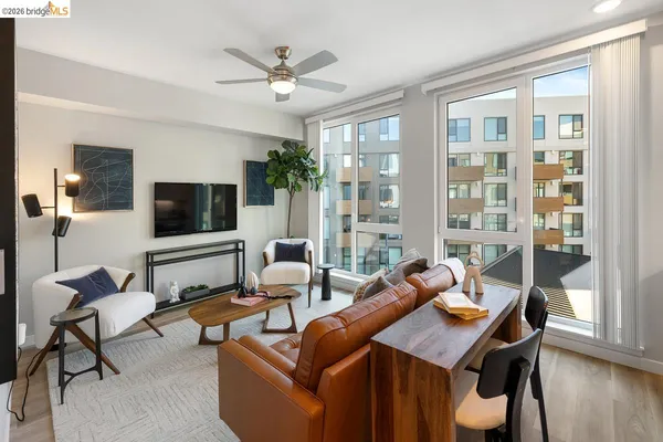 a living room with furniture a large window and a flat screen tv