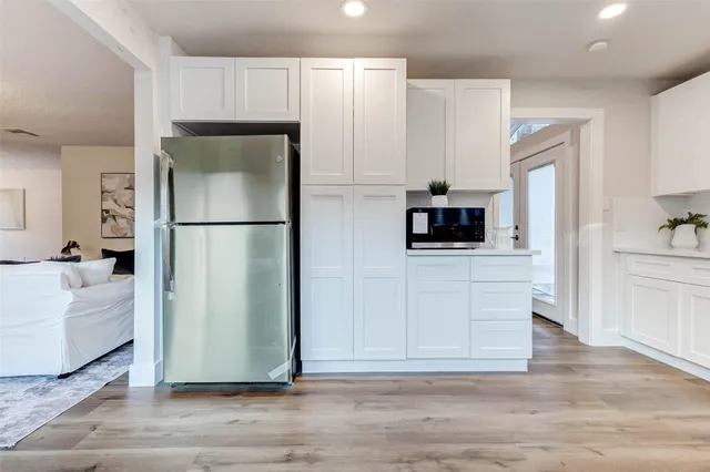 a kitchen with stainless steel appliances a refrigerator and a stove top oven