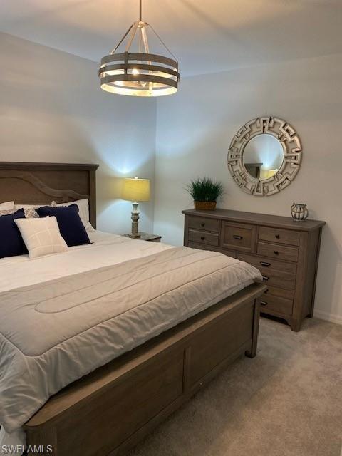 15275 Grn Acrs Avenue, Unit 337 Punta Gorda, FL 33982 - Photo 9 of 17 a bedroom with a bed and a chandelier