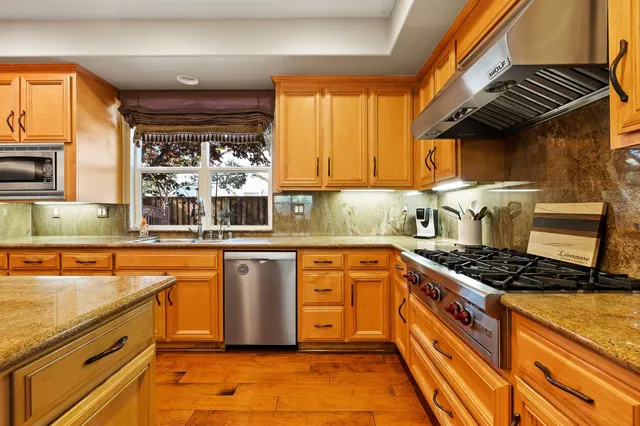 a kitchen with stainless steel appliances granite countertop a stove and a sink