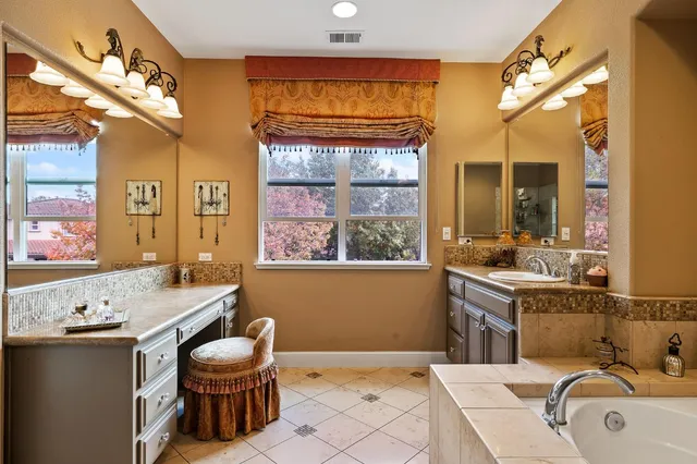 a bathroom with a granite countertop sink mirror bathtub and shower