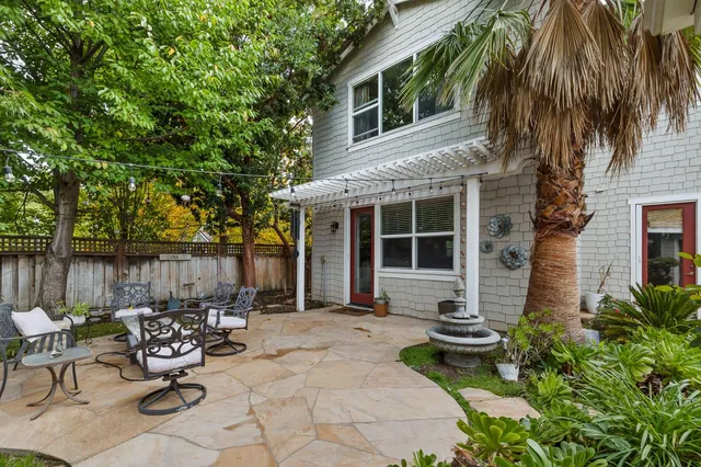 a view of a chair and table in backyard of the house