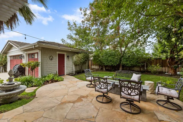a view of a backyard with sitting area and tree s