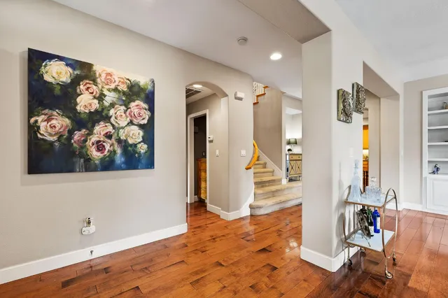 a view of a hallway with wooden floor and a living room