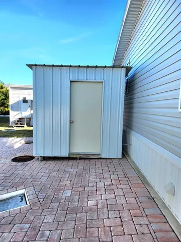 a view of a backyard with chair and potted plants