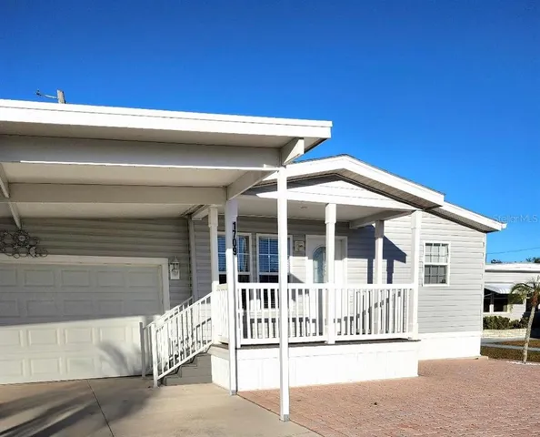 a view of a house with a small yard and wooden fence