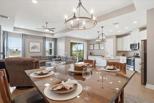 a living room with furniture kitchen view and a chandelier