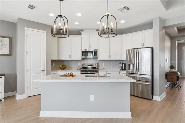 a kitchen with stainless steel appliances granite countertop white cabinets and a stove