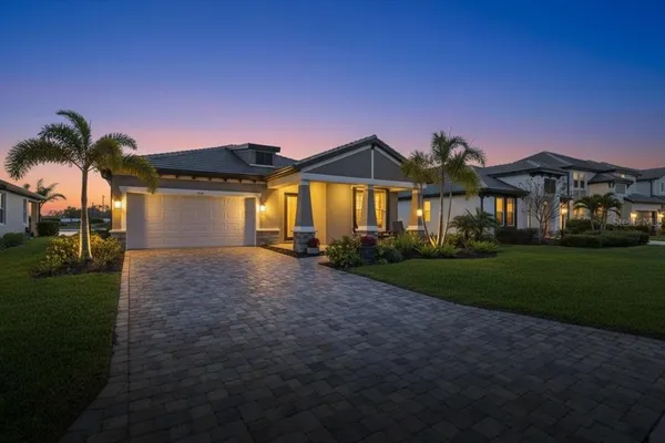 a front view of a house with a garden and yard