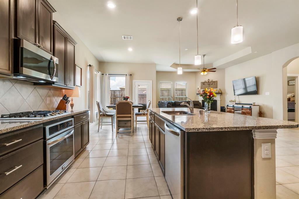 3610 Bastrop Street Melissa, TX 75454 - Photo 4 of 23 a kitchen with stainless steel appliances granite countertop a stove and a sink