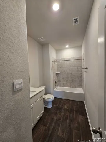 a bathroom with a granite countertop toilet and a shower