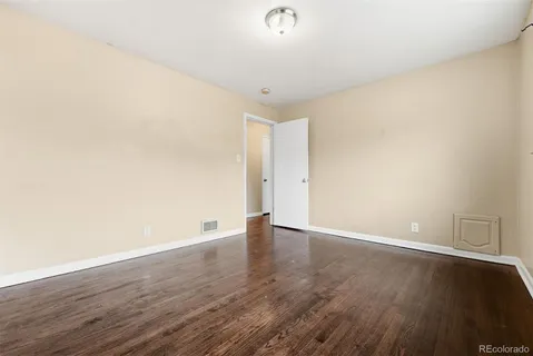 a view of an empty room with wooden floor