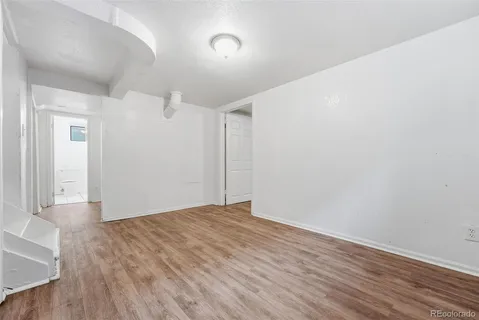 a view of empty room with wooden floor