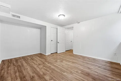 a view of empty room with wooden floor