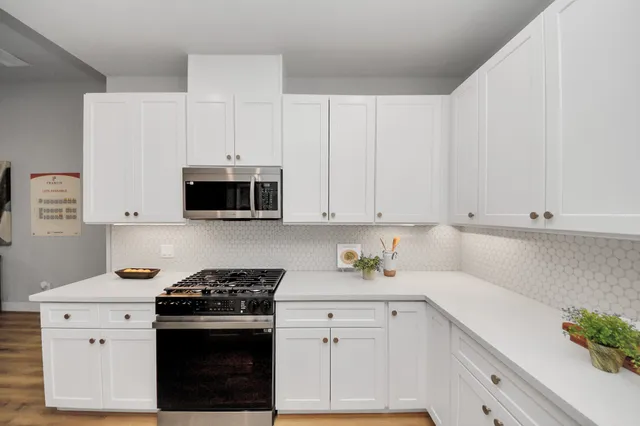 a kitchen with stainless steel appliances white cabinets and a stove a sink