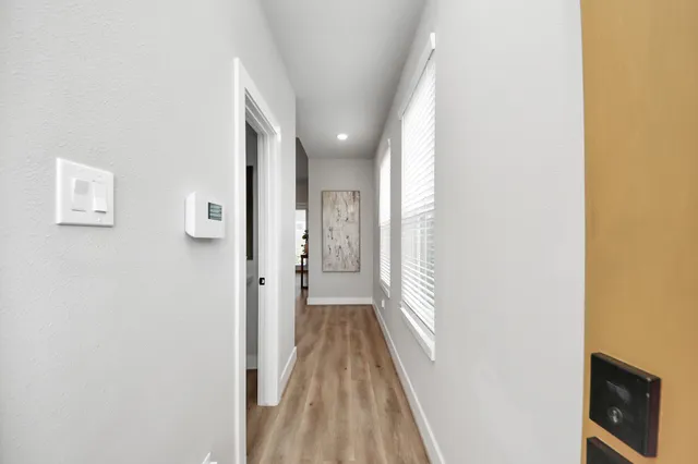 a view of a hallway with wooden floor and staircase