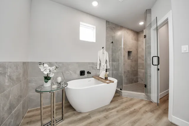 a white bath tub sitting next to a bathroom sink
