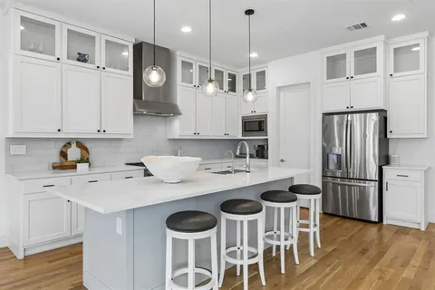 a kitchen that has a lot of cabinets a sink and appliances