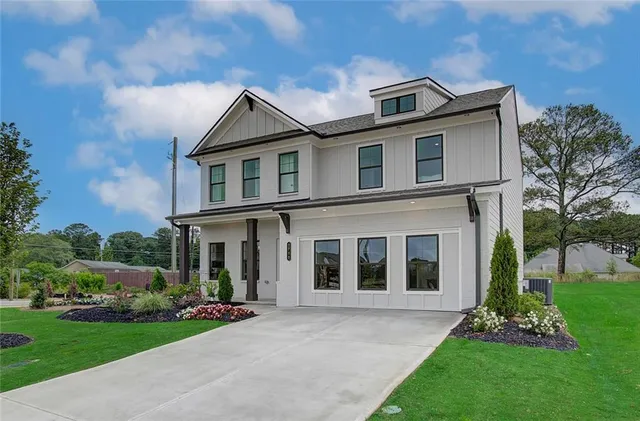 a front view of a house with a yard and potted plants