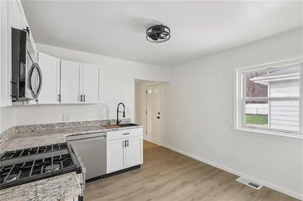 a kitchen with granite countertop a stove top oven and sink