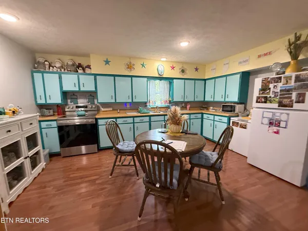 a kitchen with stainless steel appliances a table chairs and a refrigerator