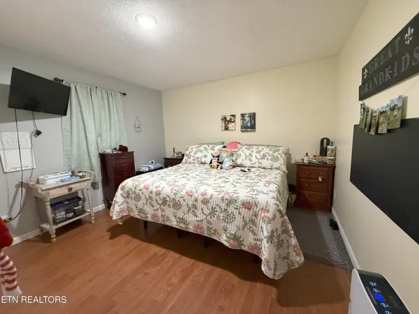 a bedroom with a bed a flat screen tv and dresser